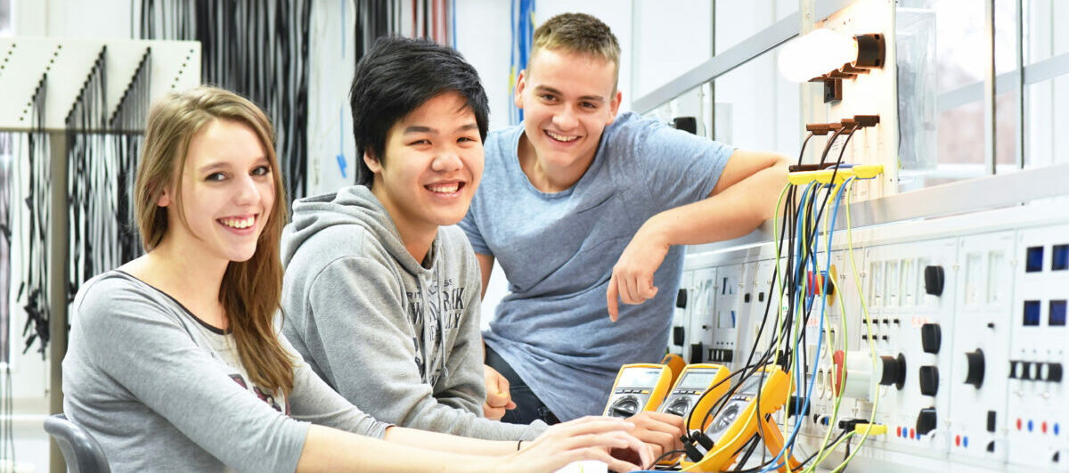 Three students collaborate in the electronics lab.