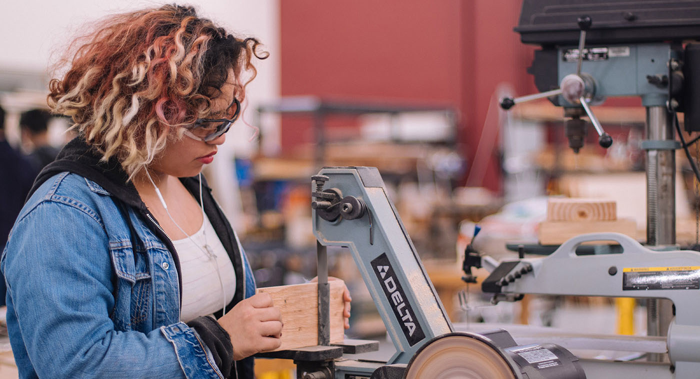 A student works on machinery in the wood shop.